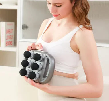 Woman using a handheld massager on her arm in a home setting