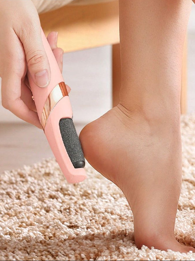 Person using a pink callus remover on their foot.